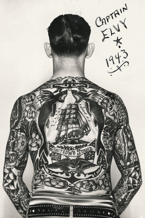 Back of a man fully tattooed. With caption on picture Captain Elvy star drawing and year 1934.